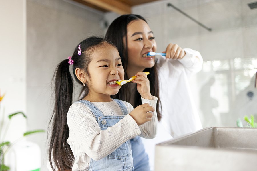 Mom and daughter brushing teeth