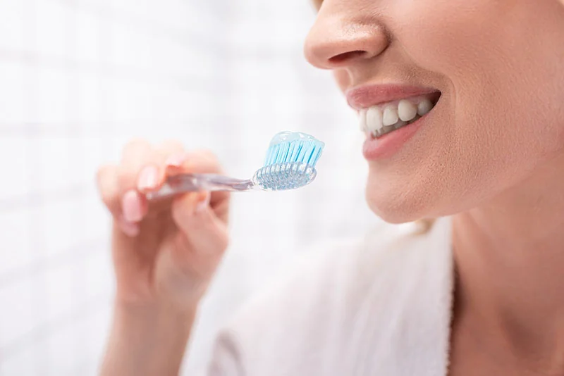 Woman smiling about to brush her teeth